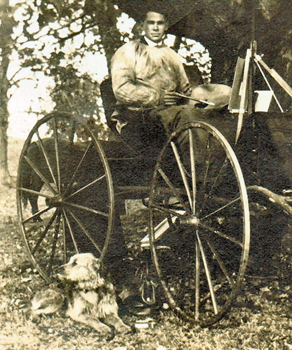 RSW in a smock, brush in hand, on his carriage with his dog.