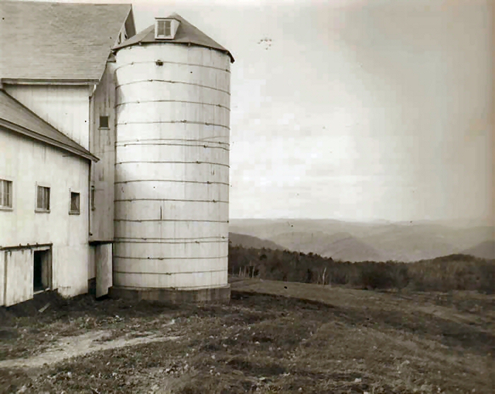A photograph of the silo and view from the farm in the painting.