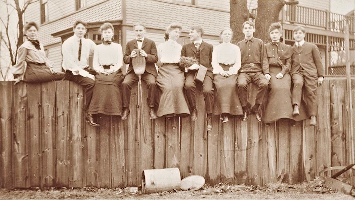 A young Woodward on a fence with friends